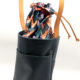 sac seau en cuir bleu et orange, doublure wax, vue de profil, la doublure est apparente et le pochon à moitié fermé par le cordon en cuir